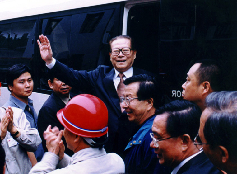 “同志們好！”“大家好！”邁出車門的江澤民向激動沸騰的西南鋁職工微笑地點頭，爽朗地問好，親切地揮手致意。（李影攝）