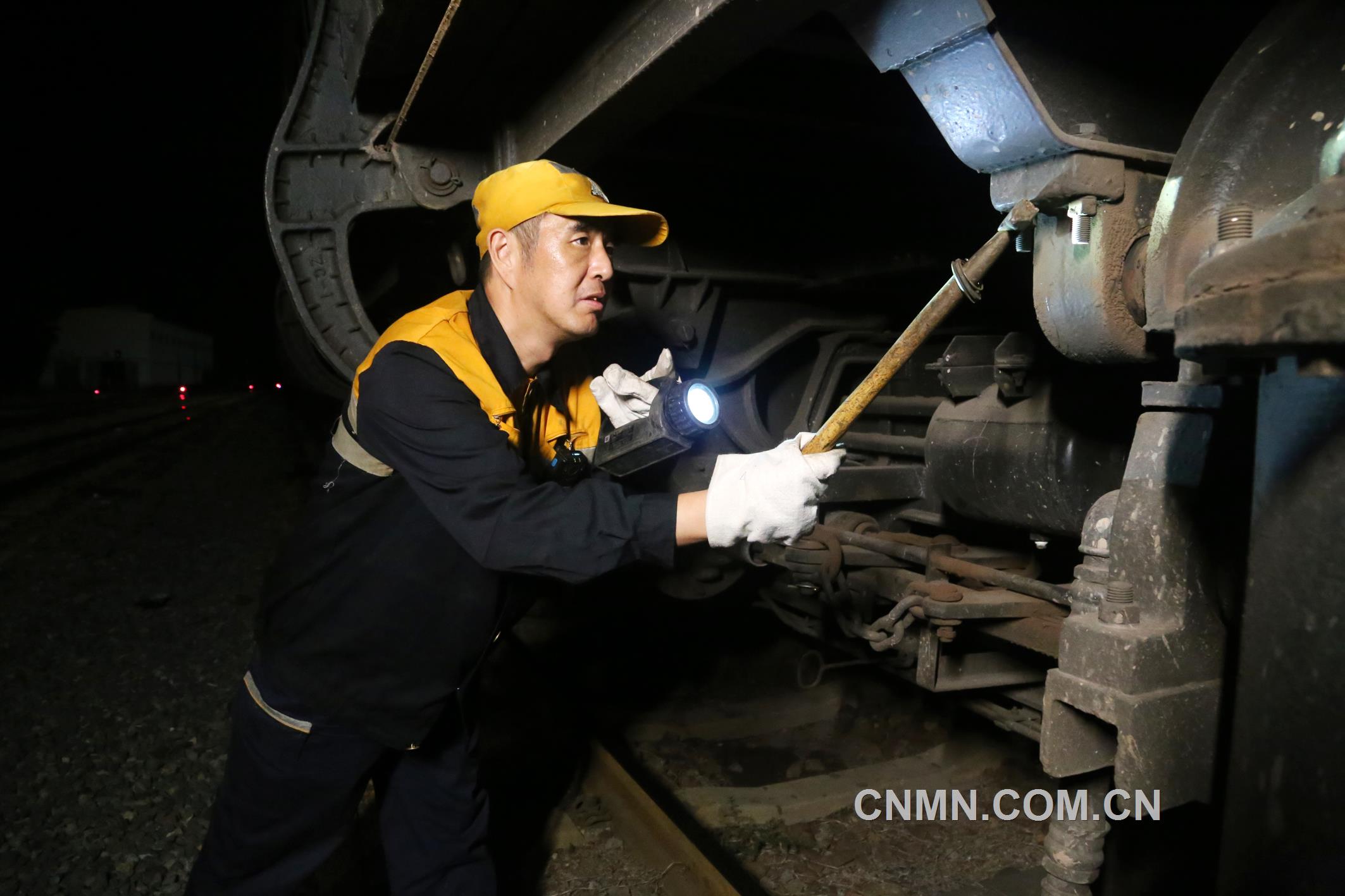 焦建智正在對待發(fā)礦石專列進行發(fā)車前的技術檢查。